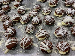 Hausgemachte Schokoladen-Doppelkekse mit Cremefüllung und weißem Zuckerguss