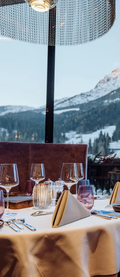 Elegant gedeckter Restauranttisch mit Bergblick durch große Panoramafenster