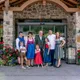 Familie in traditioneller Tracht vor Hotel mit Blumen und Steinfassade