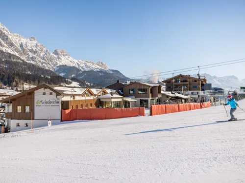 Skier approaching alpine resort Die Riederalm in snowy Leogang with mountain backdrop