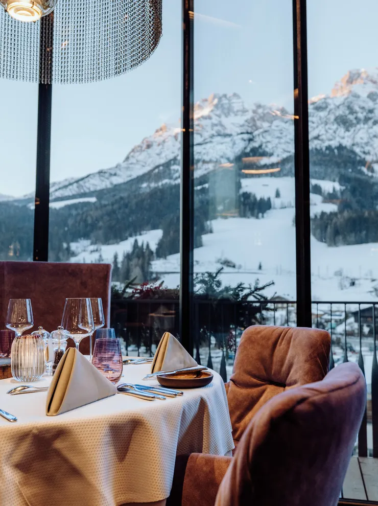 Elegant gedeckter Restauranttisch mit Bergblick durch große Panoramafenster