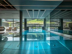 Luxury indoor pool area with lounge chairs and panoramic mountain views