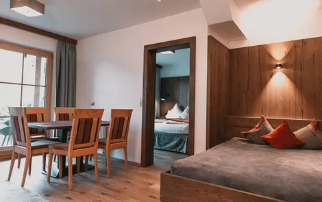 Spielberg Moderne Hotelsuite mit Essbereich, gemütlichem Bett und Blick ins separate Schlafzimmer