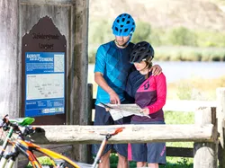 Radfahrer betrachten Wanderkarte an der Radroutine Steinberge in Leogang