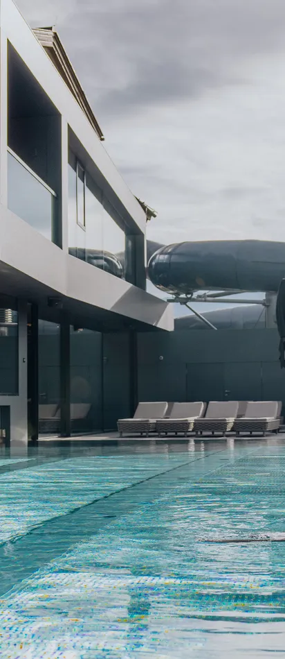 Paar entspannt am Außenpool eines modernen Hotels mit Spa und Wasserrutsche