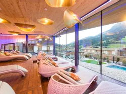 Luxury spa relaxation lounge with panoramic mountain view and modern wicker loungers
