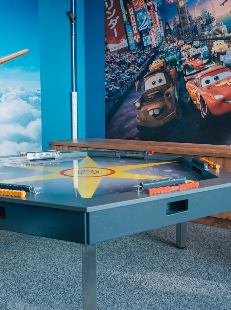 Spielzimmer für Kinder mit Cars- und Planes-Filmtapeten und interaktivem Spieltisch