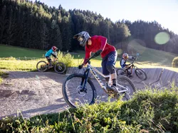 Gruppe von Mountainbikern auf einem Schottertrail im Outdoor-Bikepark