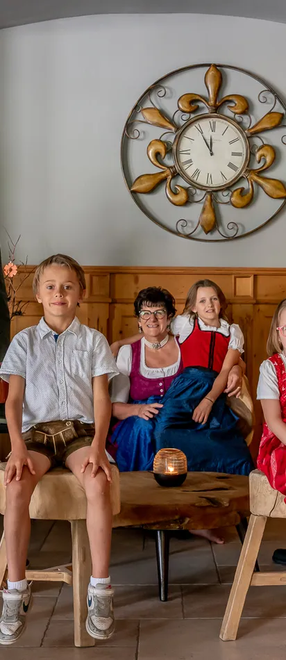 Familienporträt in traditioneller Tracht vor einem Kamin im gemütlichen Wohnzimmer