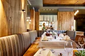 Modern restaurant interior with set tables and view into open kitchen