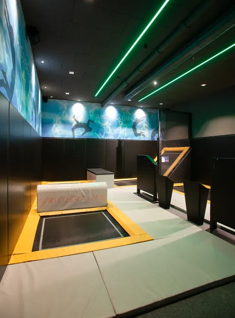 Indoor trampoline park at Riederalm with padded floors and neon lighting