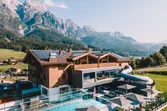 Alpine resort hotel with outdoor pool and waterslide overlooking mountain landscape