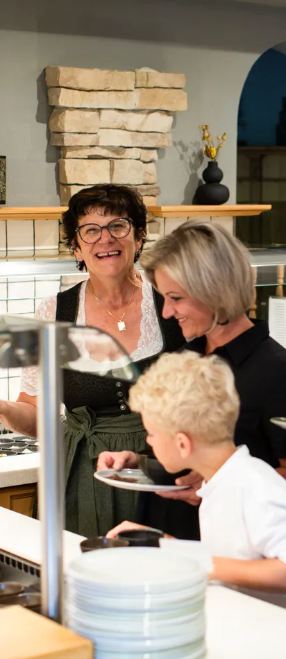 Familie am Frühstücksbuffet in einem Hotel mit freundlicher Bedienung