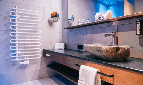 Modernes Badezimmer mit Steinkochbecken, Handtuchheizung und Wandspiegel