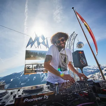 DJ performing at White Pearl Mountain Days with snowy Alps in the background