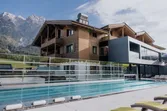 Modern wellness hotel with outdoor pool and mountain views in alpine setting