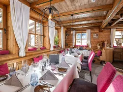 Gemütliches Restaurant im Alpenstil mit Holzeinrichtung und gedeckten Tischen