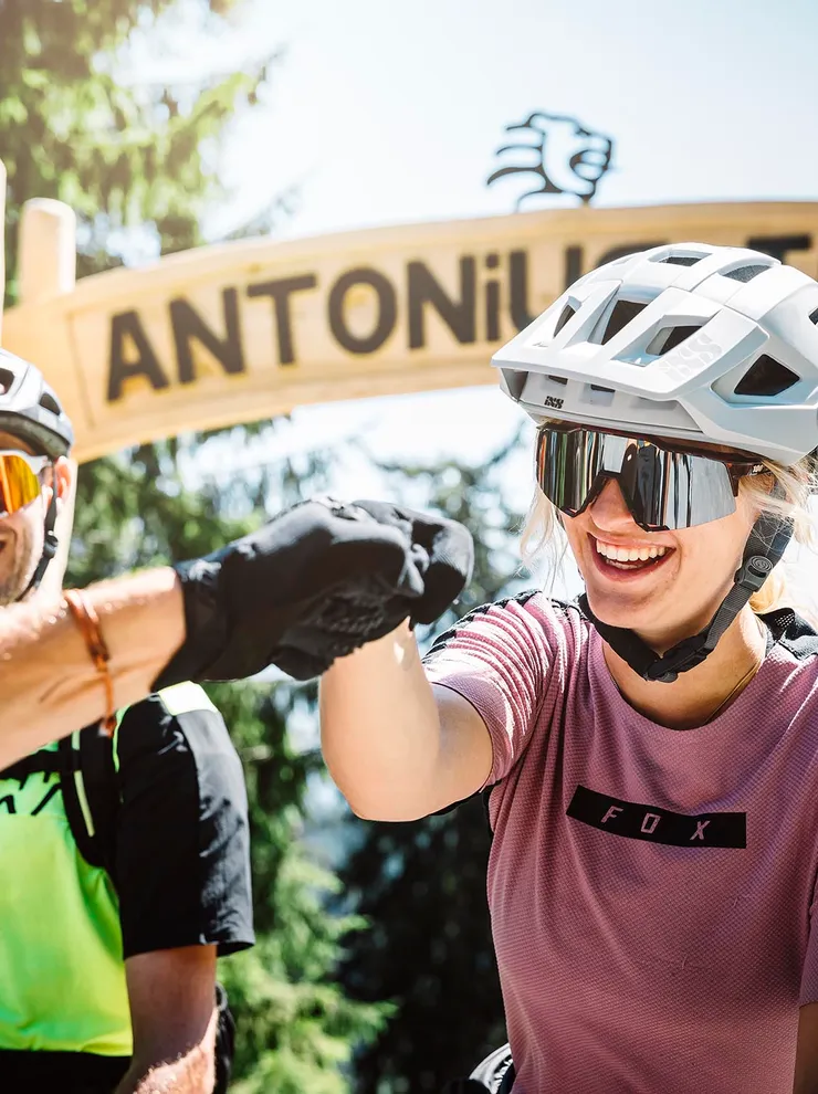 Mountainbiker geben sich Fistbump vor dem Start des Antonius Trail im Wald