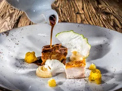 Gourmet Schweinefleisch mit Blumenkohlpüree, gelbem Blumenkohl und Sauce serviert