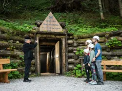 Familie mit Helmen vor dem historischen Barbarastollen im Schwarzwald mit Führer