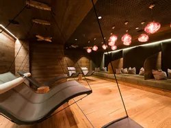 Moderner Spa-Ruheraum mit hängenden Liegestühlen und warmer Ambientebeleuchtung