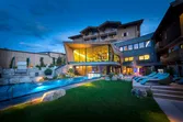 Luxushotel mit Außenpool, moderner Architektur und Liegestühlen bei Abenddämmerung