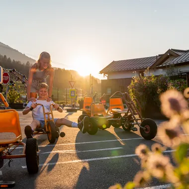Children playing with pedal go-karts on a sunny day in Salzburg outdoor area