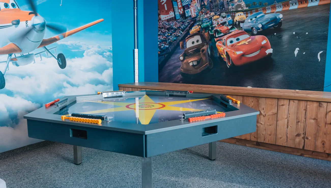 Children’s playroom with Cars and Planes movie murals and interactive game table