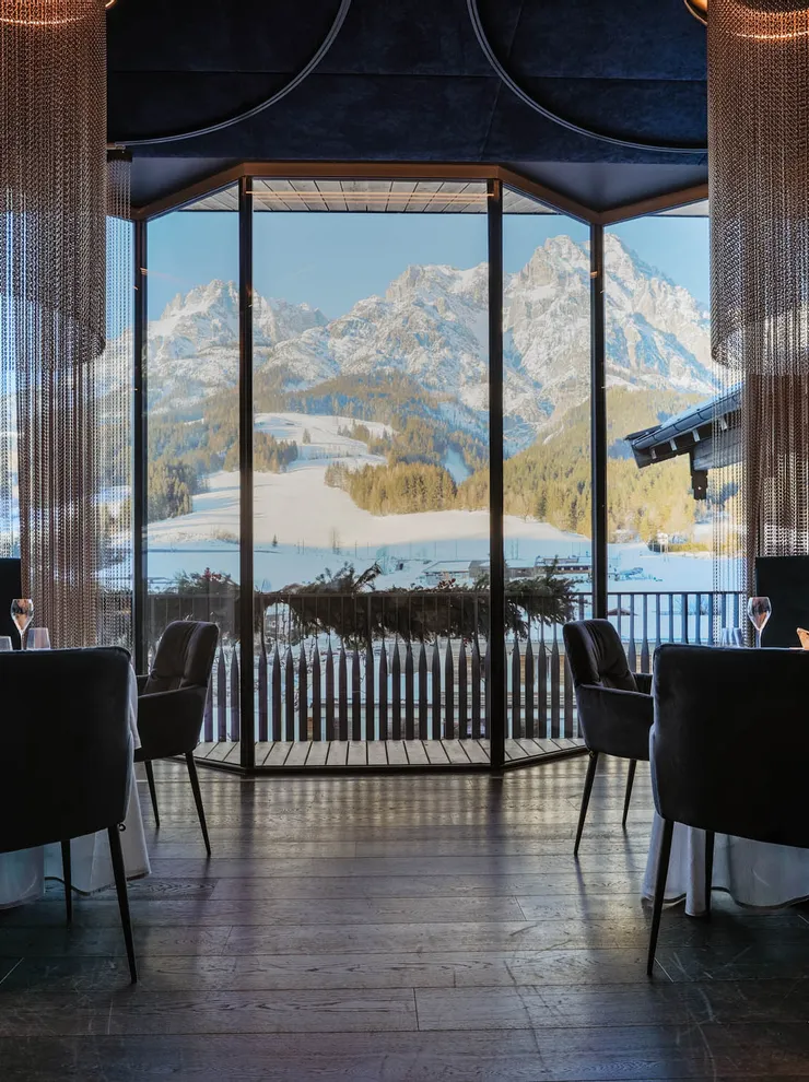 Elegant restaurant interior with mountain view through large panoramic windows