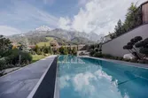 Modern outdoor pool with mountain view in luxurious alpine resort setting