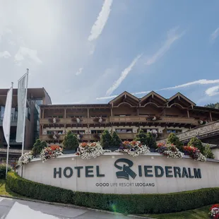 Hotel Riederalm in Leogang mit alpiner Holzarchitektur und blumengeschmückten Balkonen