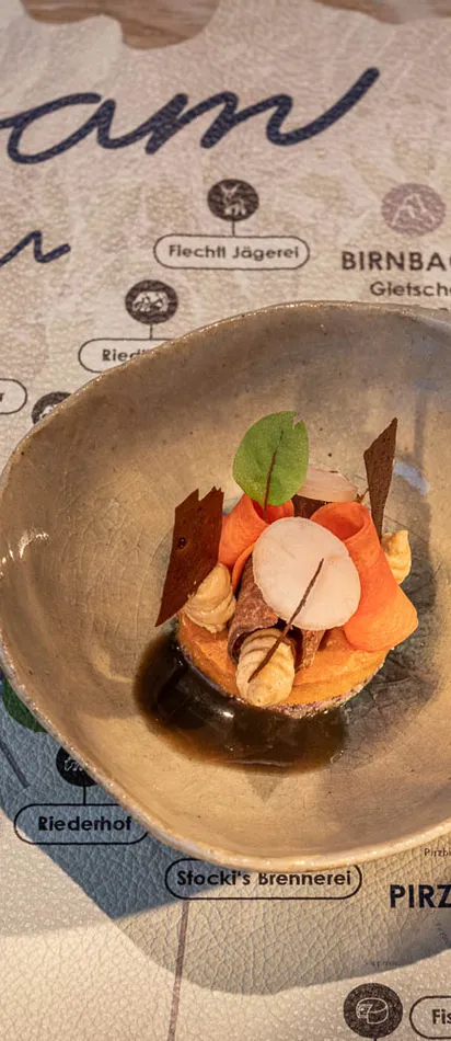 Gourmet appetizer in ceramic bowl displayed on a Leogang region map