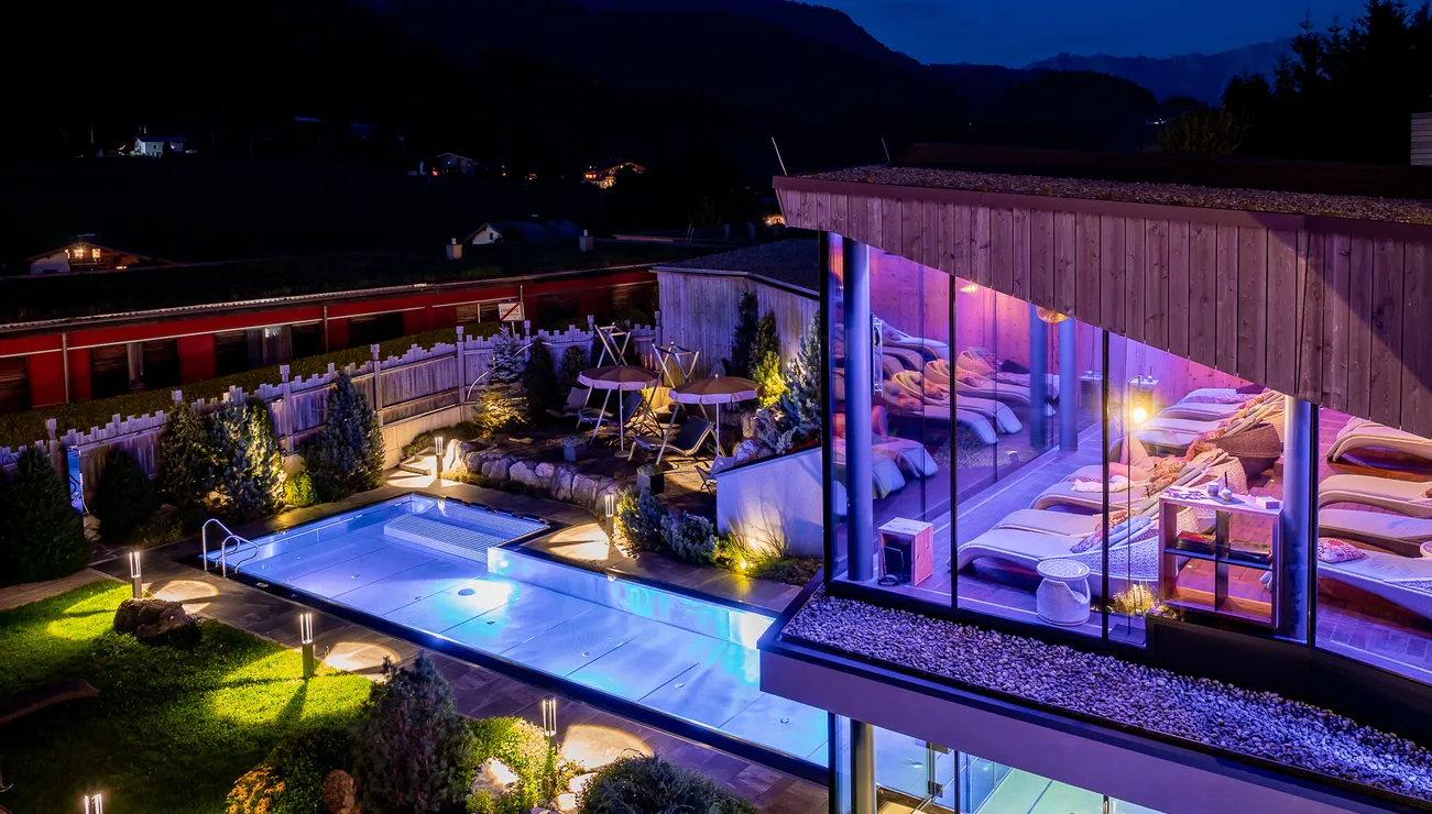Luxuriöses Spa-Hotel mit Außenpool und beleuchtetem Ruhebereich bei Nacht