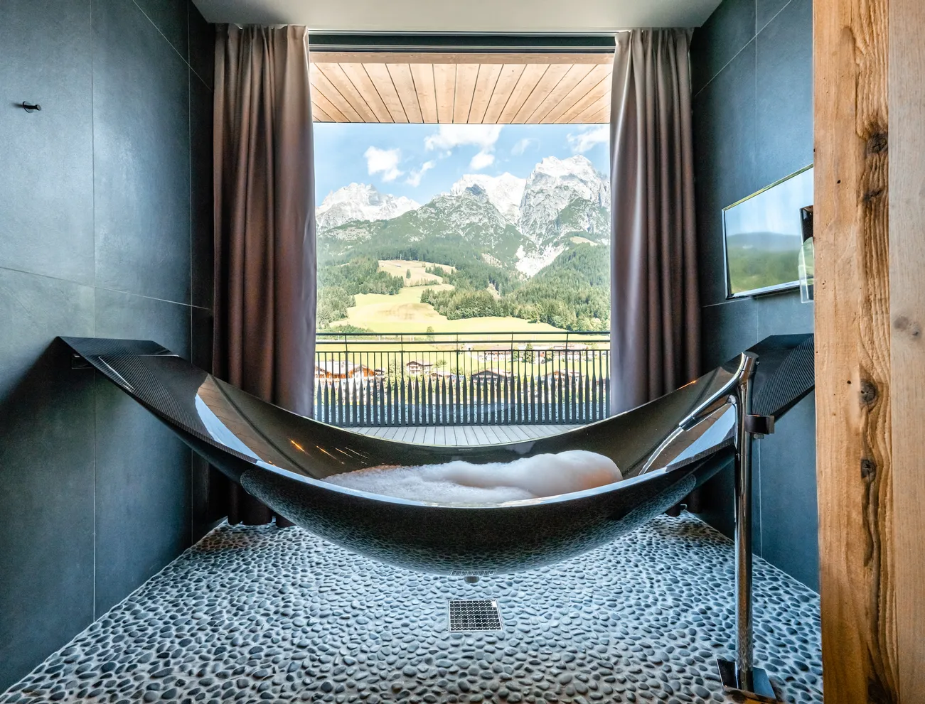 Modern freistehende Badewanne mit Bergblick im Luxus-Hotelzimmer