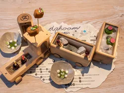 Gourmet appetizer served in wooden toy train with small dishes and creative plating