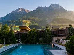 Outdoor hotel pool with mountain view in the Austrian Alps at sunrise