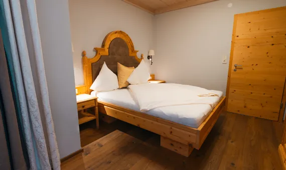 Cozy bedroom with wooden frame bed and nightstands in rustic style