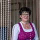 Smiling woman wearing a traditional dirndl dress with decorative apron and necklace