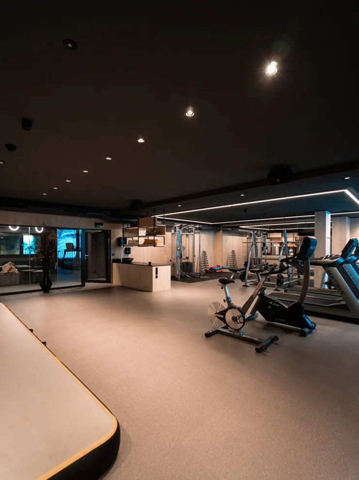Modern gym interior with exercise bike, weights, and strength training equipment