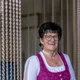 Lächelnde Frau in traditionellem Dirndl mit Schürze und Halskette