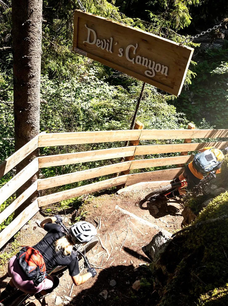 Mountainbiker fahren den Waldpfad in der Devil's Canyon mit Holzgeländer hinunter