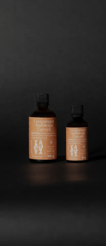 Two bottles of Leoganger Saiblings Garum fish sauce on dark background