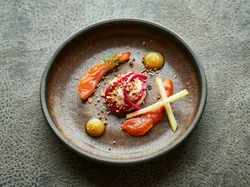 Gourmetgericht mit Räucherlachs, Rote-Bete-Püree, Apfelsticks und Sauce auf rustikalem Teller