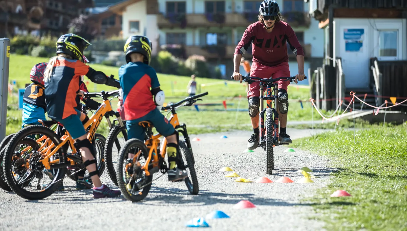 Mountain bike instructor teaching kids riding skills during an outdoor training session