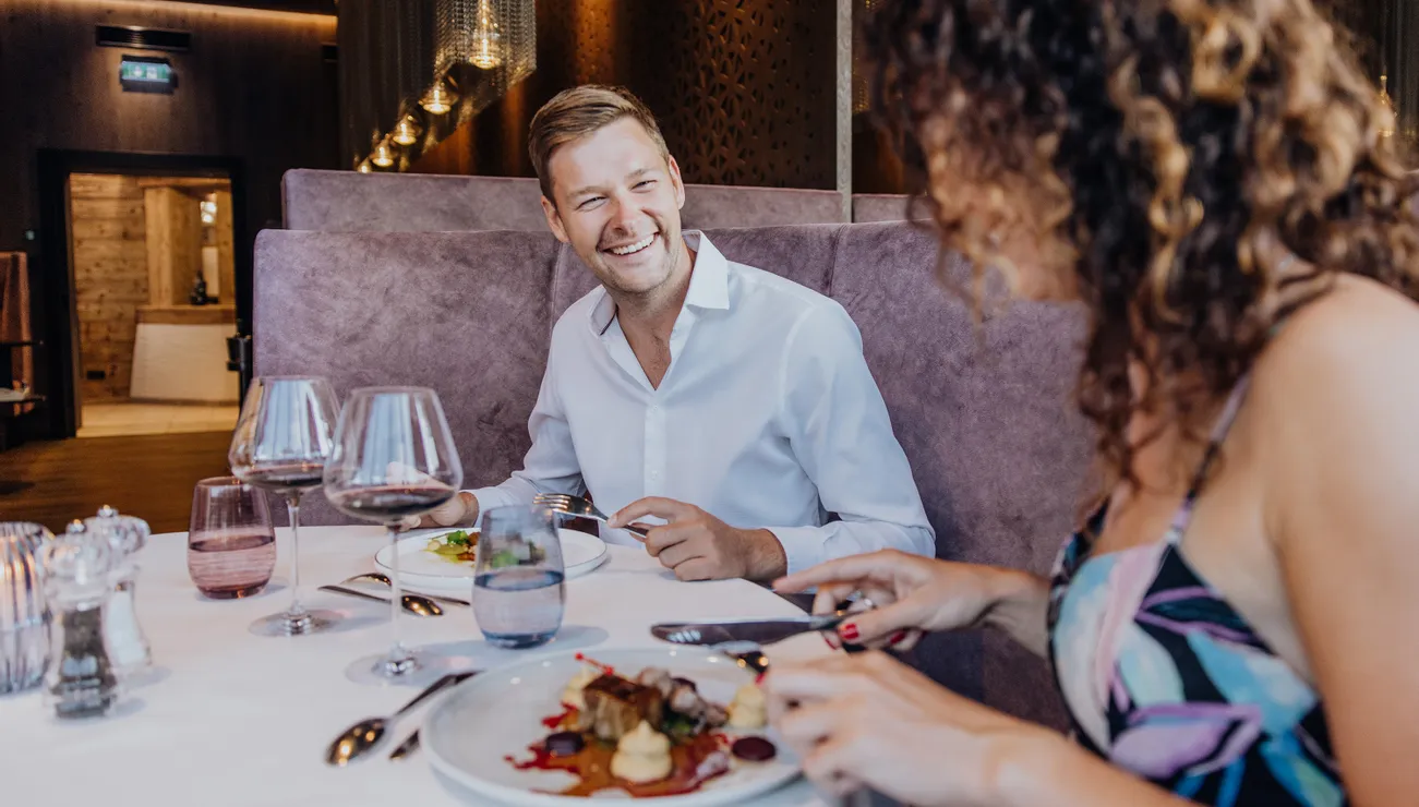 Smiling couple enjoying fine dining with wine in a modern upscale restaurant