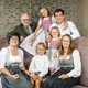 Smiling family wearing traditional Bavarian clothing seated together indoors