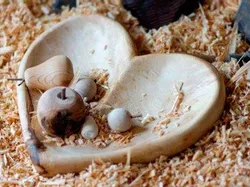 Herzförmige Holzschale mit kleinen Drechselarbeiten auf Holzspänen
