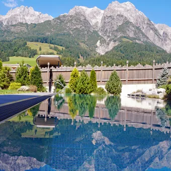Outdoor pool with mountain view and clear reflection on a sunny day