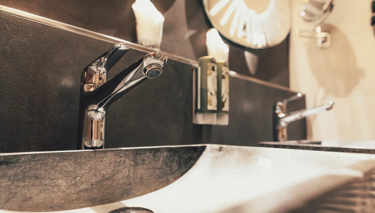 Modern bathroom faucets with wall-mounted mirror and soap dispensers