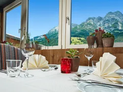 Elegant restaurant table set with mountain view through large windows